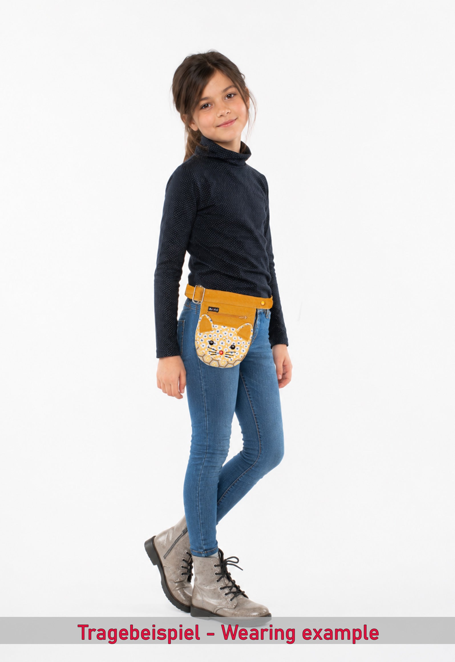 Das Fotomodell ist ca. 125 cm groß und trägt die Kids Side Pocket "Kitty" als Gürteltasche auf Hüfthöhe. Abgebildet ist die Designvariante Kitty. Weitere Designs sind separat erhältlich.